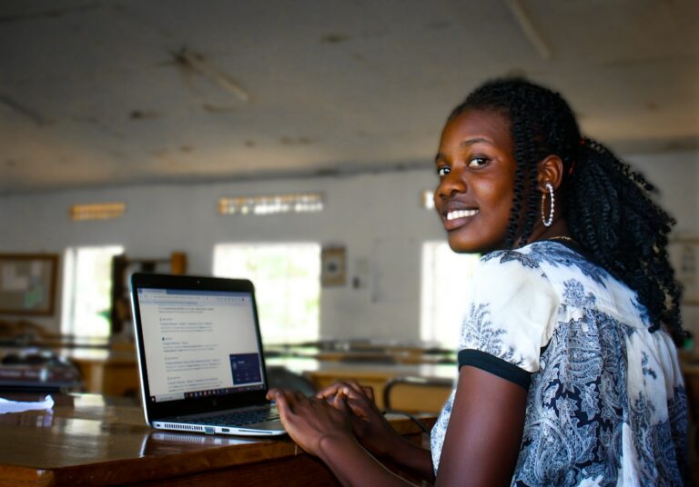 a woman sitting in front of a laptop computer