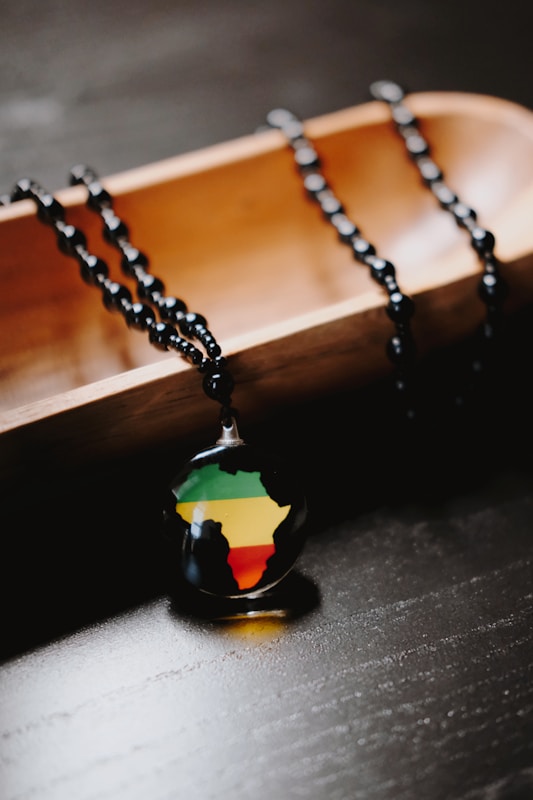 Necklace with africa map pendant displayed on wood.